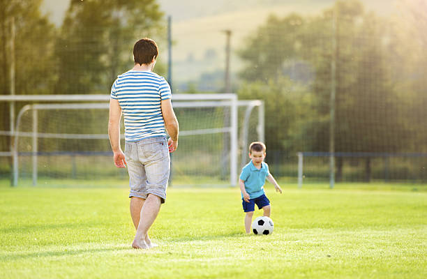 istock Father and son playing football 498212189