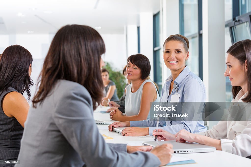 Businesswomen meeting Group of businesswomen having meeting, working together and discussing. Focus on the woman smiling at camera. Job Fair Stock Photo