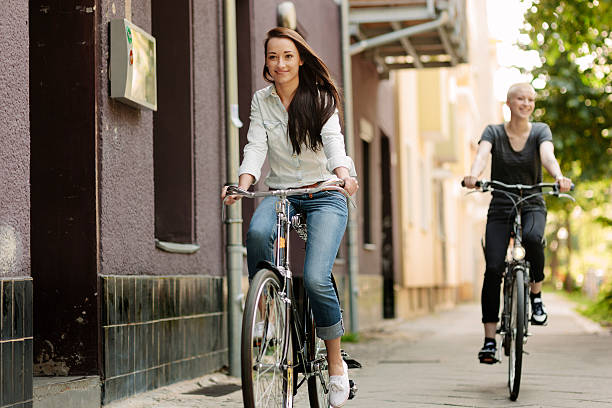 istock Smiling young women riding bicycles together 498215059