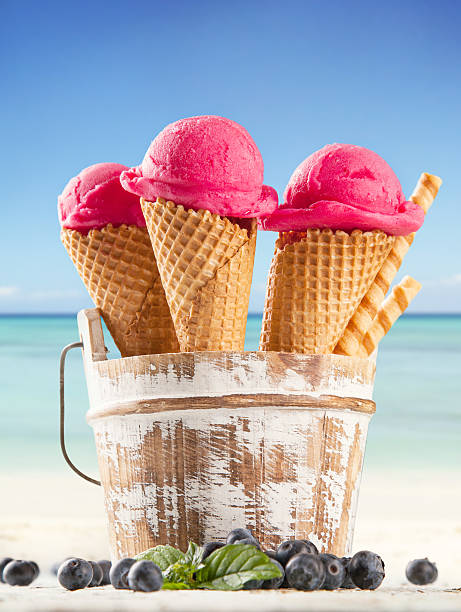istock Ice cream scoops in cones with blur beach 498236415