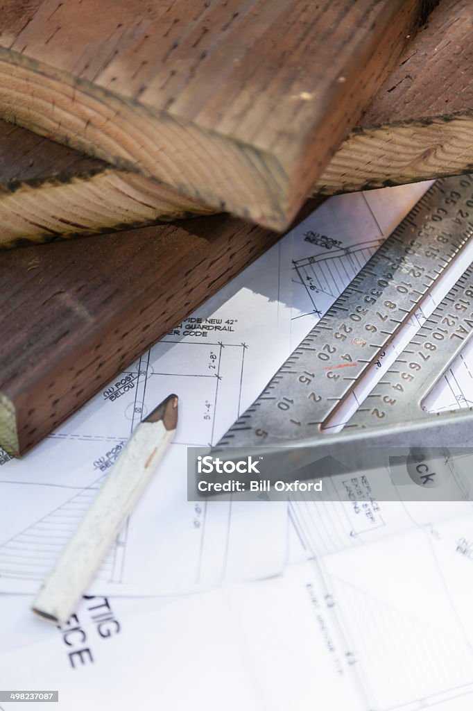 Construction and Building Carpenter tools on redwood boards. Shot at actual construction site. Blueprint Stock Photo