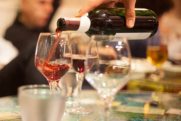 istock waiter pouring red wine into glasses 498238653
