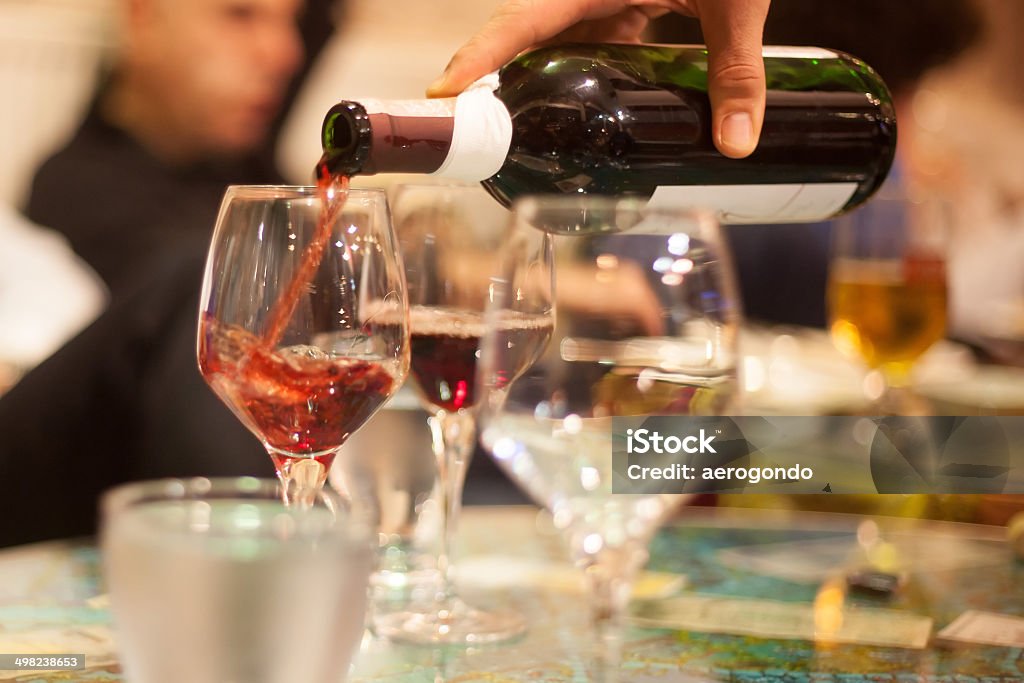 waiter pouring red wine into glasses Alcohol - Drink Stock Photo