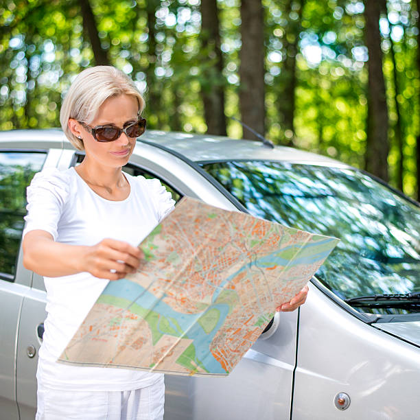 istock Woman Reading Map in front of the car 498239611