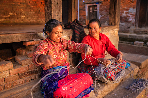 Nepali women spinning a wool in front of the house. Bhaktapur in Kathmandu valley. Nepal.http://bem.2be.pl/IS/nepal_380.jpg