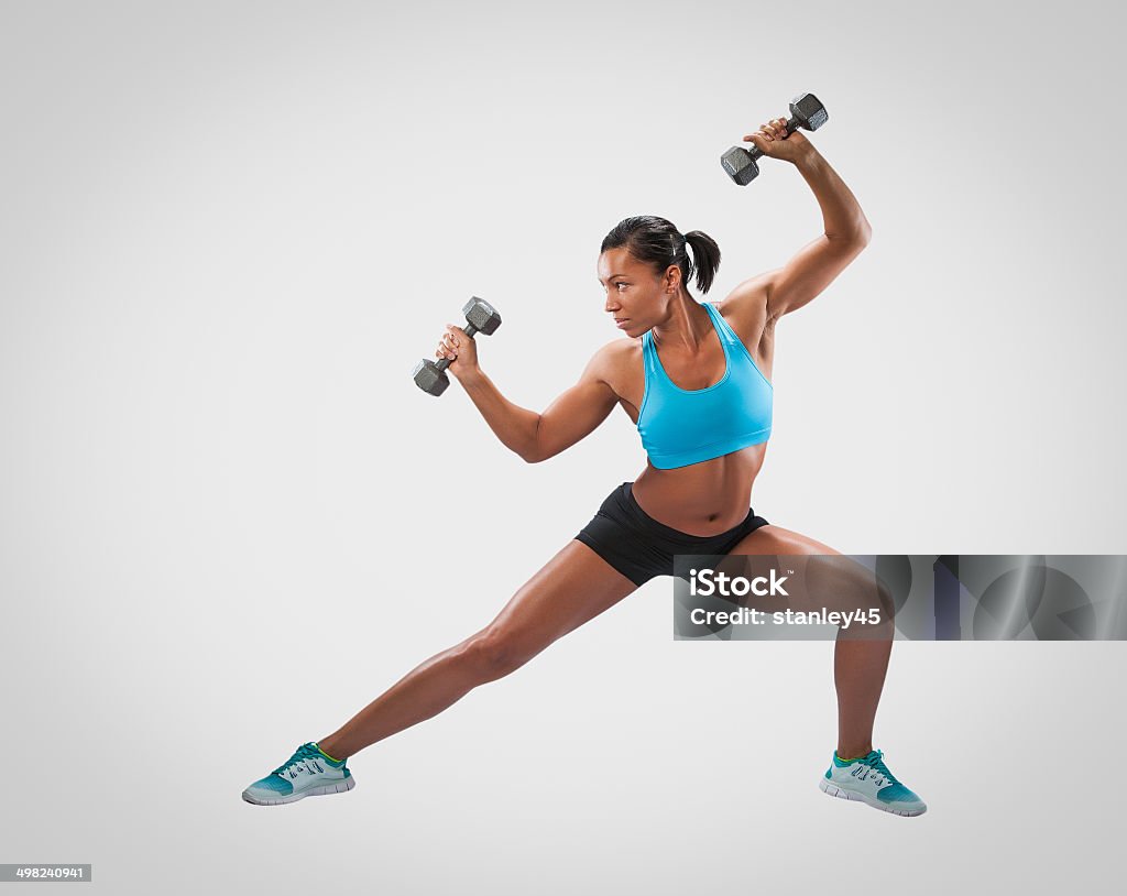Strength Training Exercises Fit African-American woman lifting weights against a studio background 30-39 Years Stock Photo
