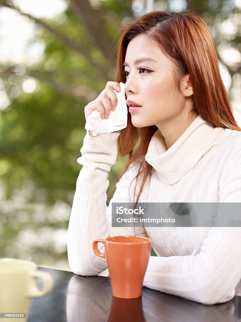 sad woman young woman wiping tears with facial tissue. Crying Stock Photo