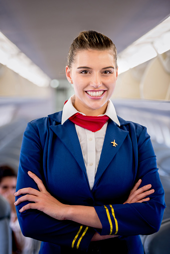 Happy flight attendant smiling in an airplane