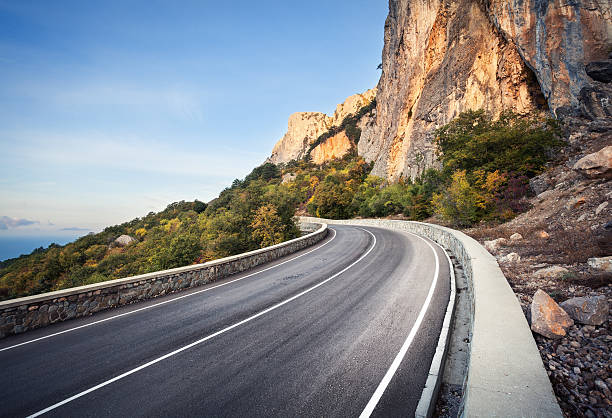 istock Beautiful asphalt road in autumn forest at sunrise. Mountains 498246396