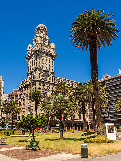 Montevideo, Uruguay - January 26, 2013: Palacio Salvo seen from Plaza Independencia. Upon closer inspection, a man can be seen sitting beside the police box.
