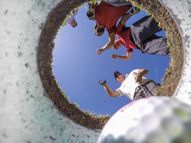 istock Point Of View Golf Players and Ball From Inside Hole 498250366