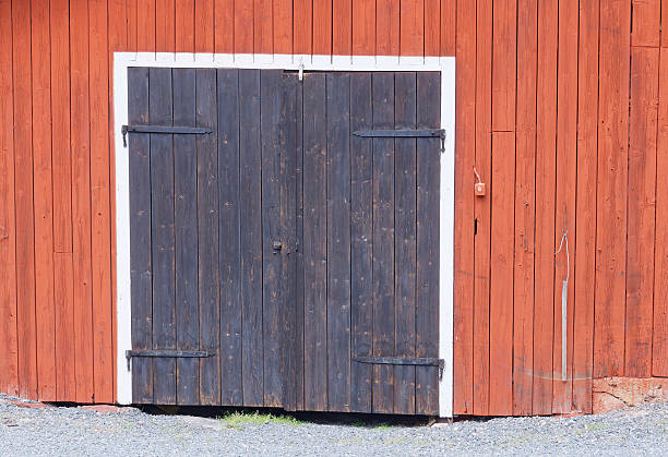 ブラックのドアを 1 つの赤のクローゼットの壁 - barn red old door ストックフォトと画像