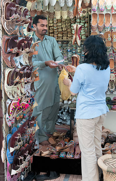 asiatische frau tourist, für schuhe mit bargeld, dubai, vae - shoe men indian culture indian ethnicity stock-fotos und bilder