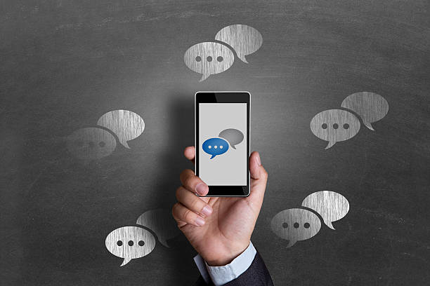 istock Businessman showing chat bubbles icons on mobile phone 498274292