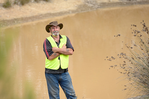 Typical Australian Farmer by his farm dam, holding water for the harsh summers. Dealing with droughts and bush fire season.