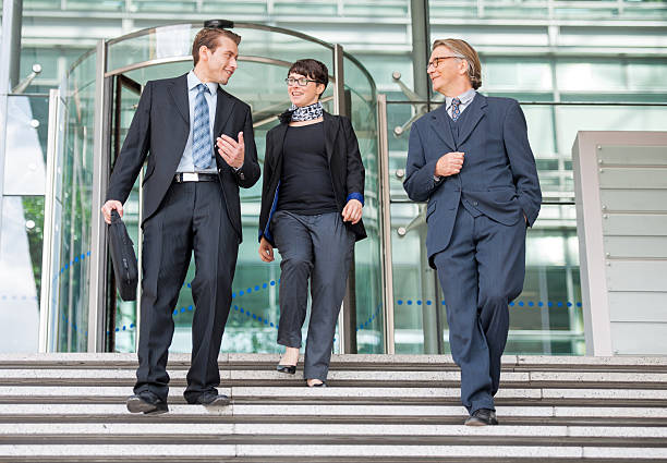 istock Smiling businesspeople walking down the stairs and communicating 498276530