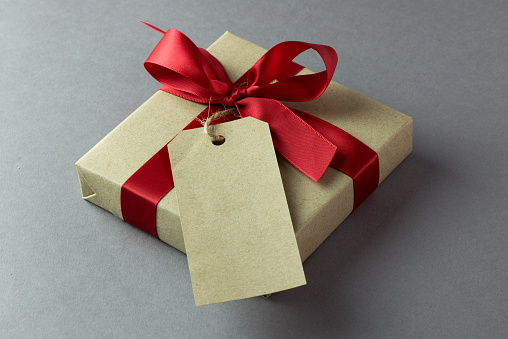Rustic gift box with empty tag and red bow