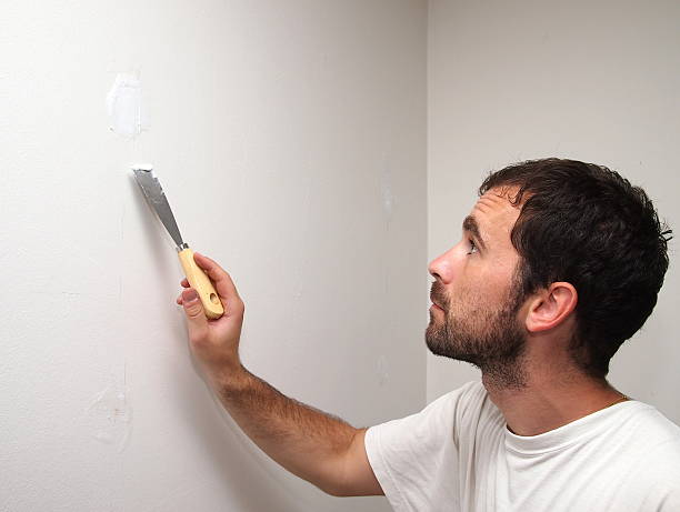 istock Man covering holes with a cement. 498278918