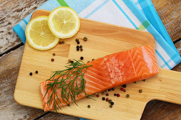 istock Uncooked salmon steak with lemon on wooden board 498281680