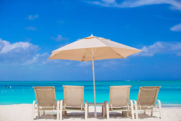 istock White umbrella and sunbeds at tropical beach 498281843