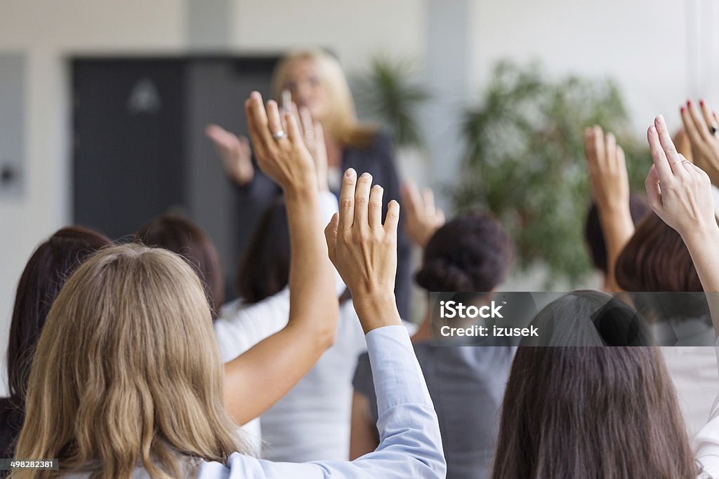 Seminar for women Group of businesswomen attending a seminar, raising their hands. Focus on hands. Auction Stock Photo