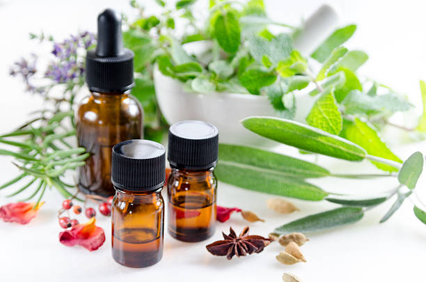 alternative therapy with herbs and essential oils alternative therapy with herbs and essential oils in white background aromatherapy oil photos stock pictures, royalty-free photos & images