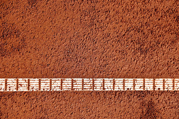 Close up of black tennis racket with brown leather handle strap and yellow tennis ball on white background