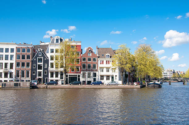 амстердам городской пейзаж в начале весны в солнечный день. нидерланды. - europe sunlight river sun стоковые фото и изображения