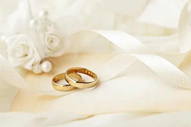 two wedding rings and wedding invitation