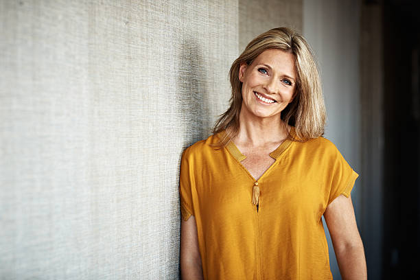 Feeling right at home... Portrait of a smiling mature woman at home older blonde woman stock pictures, royalty-free photos & images