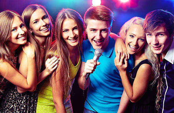 Young people singing at party stock photo