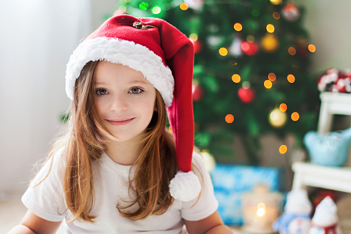 Beautiful Christmas close portrait of little preschool girl at home, dreaming