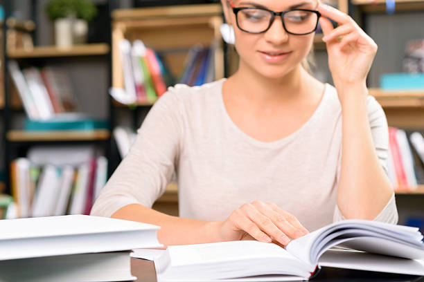 istock Girl wears glasses to read a textbook 498303106