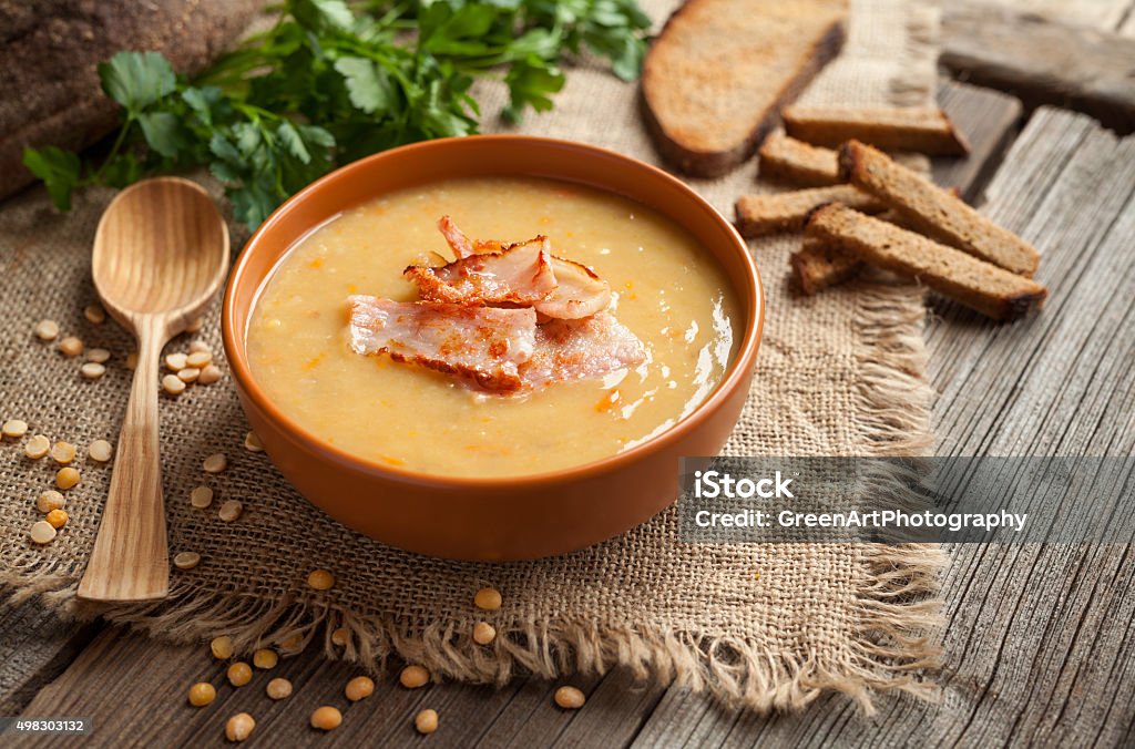 Traditional german homemade pea soup preparation recipe with bacon greens Traditional german homemade pea soup preparation recipe with bacon greens and croutons in clay dish on vintage wooden table background. Tasty national food. Rustic style. Soup Stock Photo