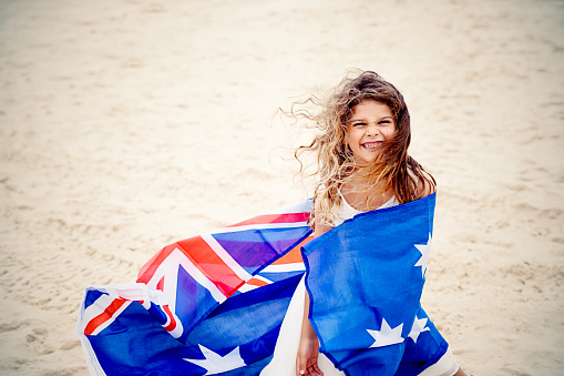 Preschool girl with Australian flag on the beach