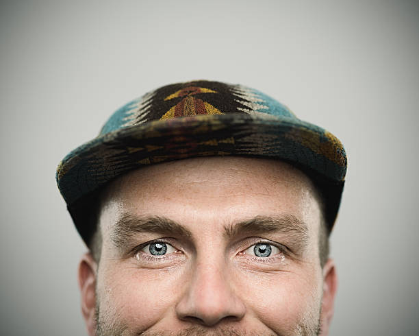 Man wearing a multi-coloured beanie over his face