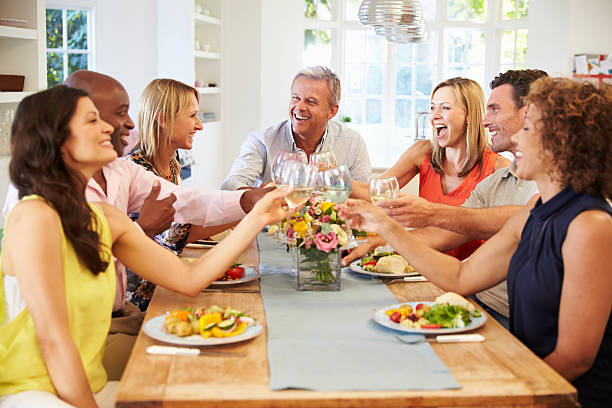 istock Mature Friends Sitting Around Table At Dinner Party 498308318
