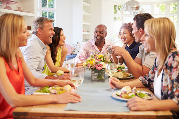 istock Mature Friends Sitting Around Table At Dinner Party 498308972