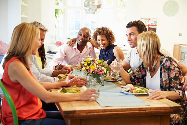 istock Mature Friends Sitting Around Table At Dinner Party 498309272