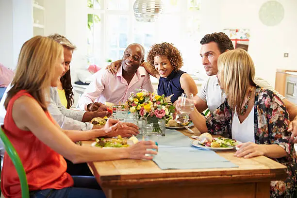 Mature Friends Sitting Around Table At Dinner Party