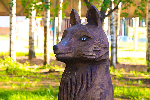 Wooden statue of fox. Photo of summer hotel complex.