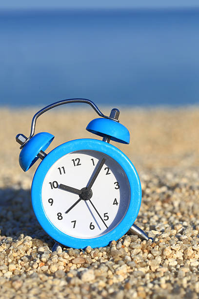 istock Vacation time. Alarm clock on the beach 498314771