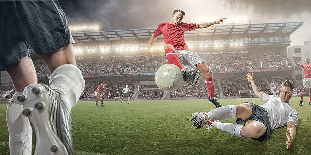 футбол игроки воздухе действий - playing field effort outdoors human age стоковые фото и изображения
