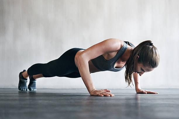 fühlt sich gut an und sieht großartig aus, die sie regelmäßig - athlete push ups muscular build female stock-fotos und bilder