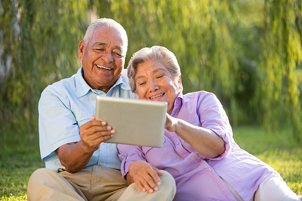 istock Latin senior couple with a tablet in park 498316777
