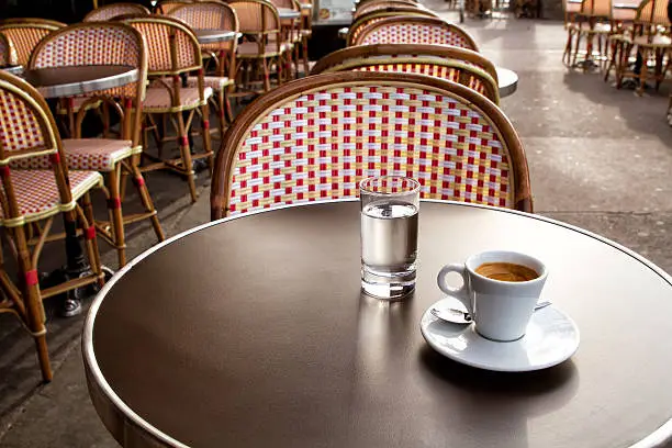 Photo of Coffee and water on a table of parisian's bar