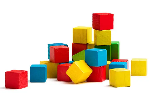 Photo of toy blocks pyramid, multicolor wooden bricks stack isolated white background