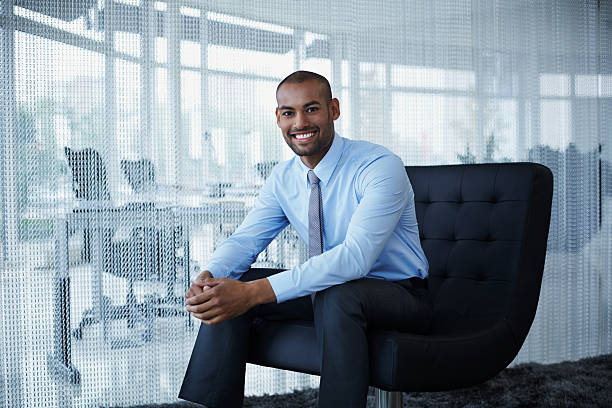 confident businessman sitting on chair - business person sitting looking at camera corporate business 뉴스 사진 이미지