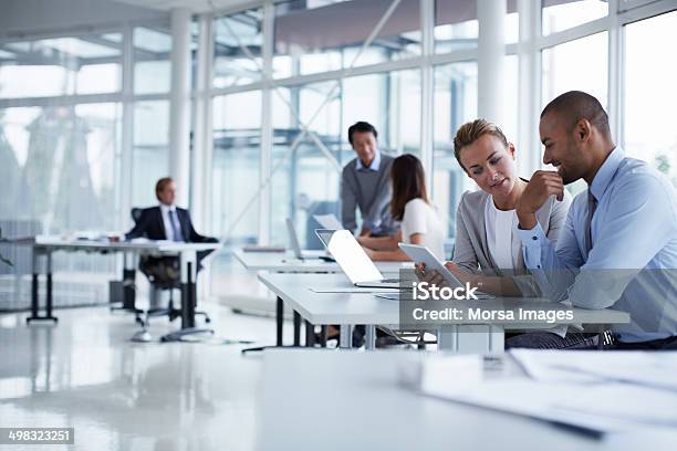 Colleagues Discussing Over Digital Tablet Stock Photo - Download Image Now - Office, Business, Technology