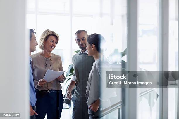 Businesswoman Discussing With Colleagues Stock Photo - Download Image Now - Business, Meeting, Teamwork